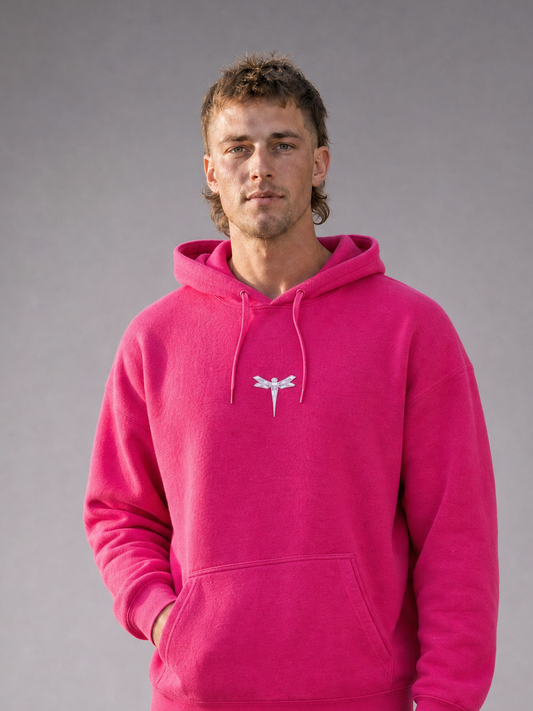 TRUST THE CHAOS Hoodie pink - Nahaufnahme Frontansicht, getragen von männlichem Model, mit kleinem Libellen-Logo auf der Brust [KI]